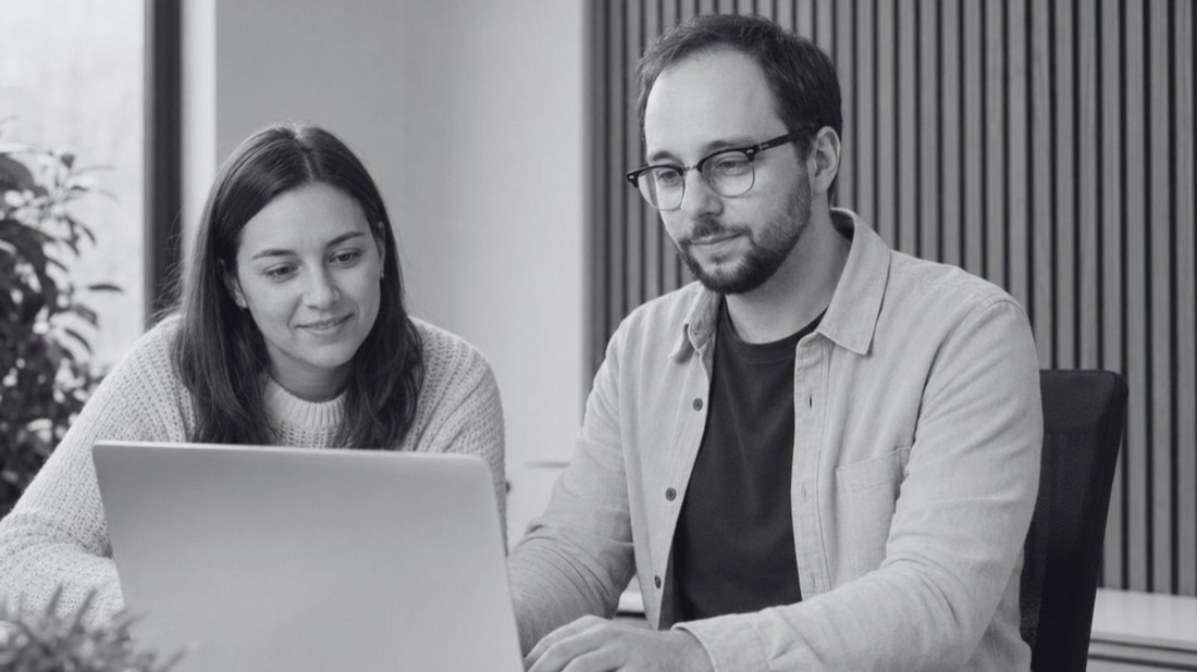 Zwei Teammitglieder arbeiten gemeinsam am Laptop